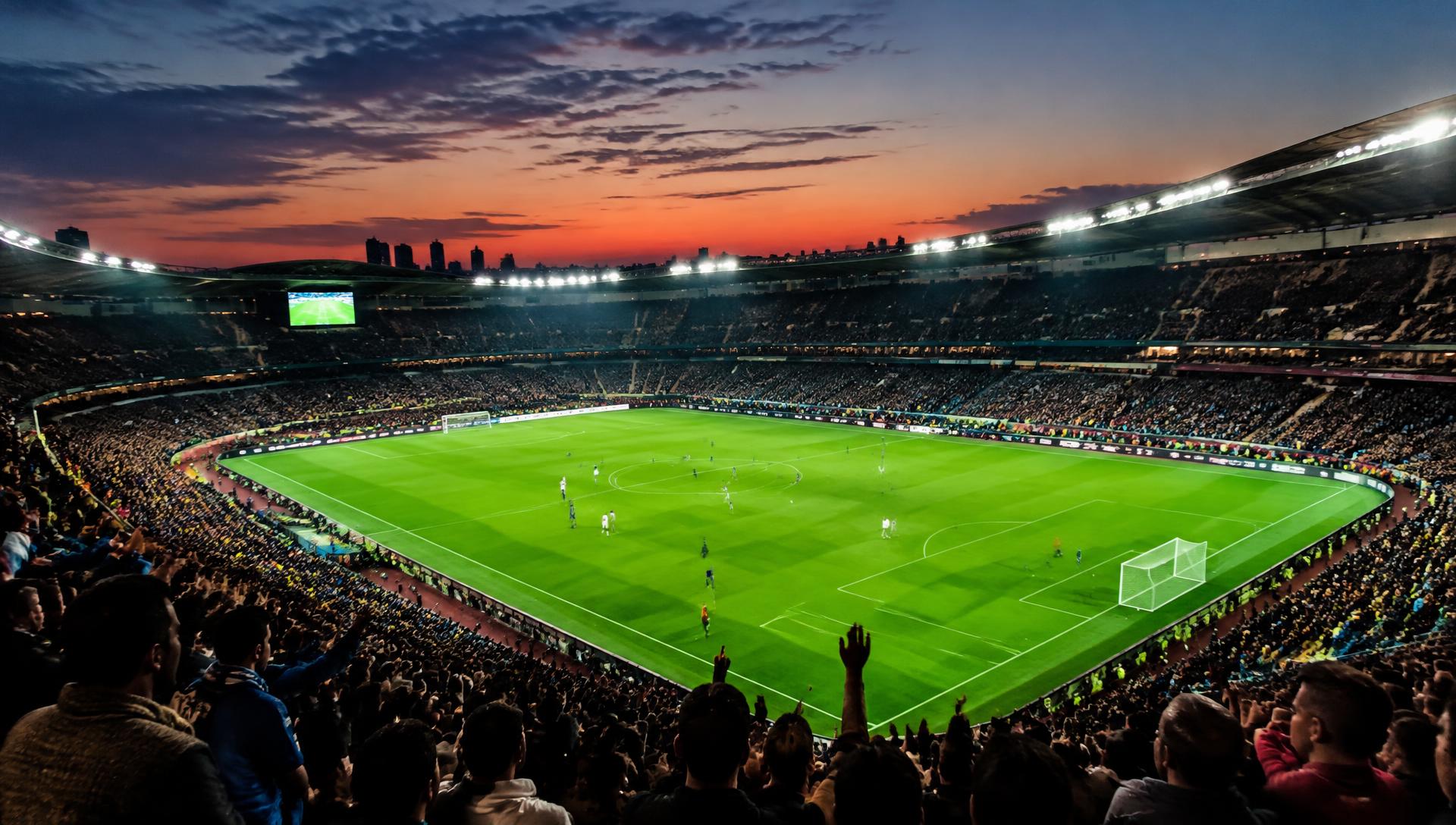 Floodlit soccer stadium packed with fans at dusk